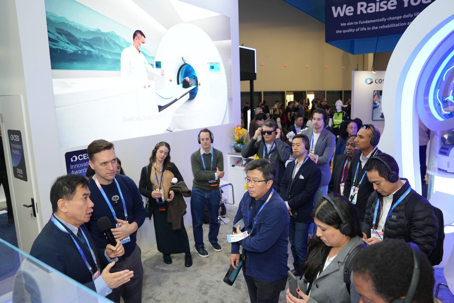 Tiposi presenting the MWI Brain Scanner to attendees during a guided tour on the CES 2026 show floor.